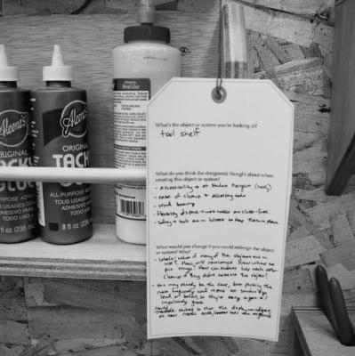 A shelf of glue and a tag with illegible printing.