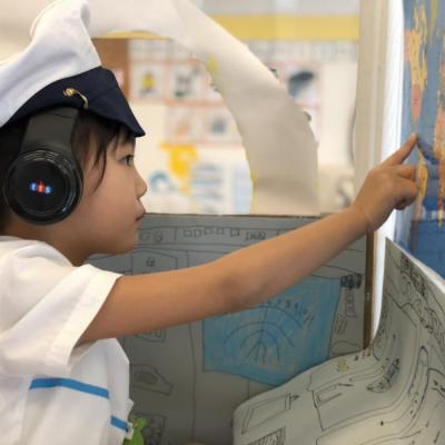 A young boy pointing to a map