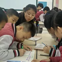 Asian students study with their teacher at a desk