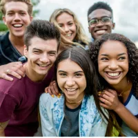 A group of teens smile at the camera