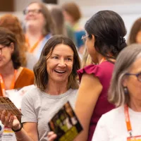 A woman smiles at a conference
