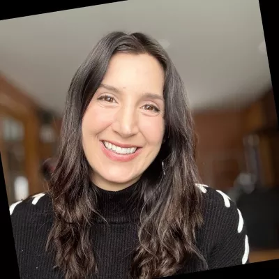 A woman smiles at the camera