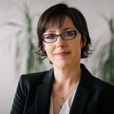 A woman smiles at the camera