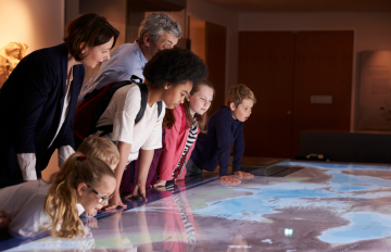 Children and adults look at a museum exhibit